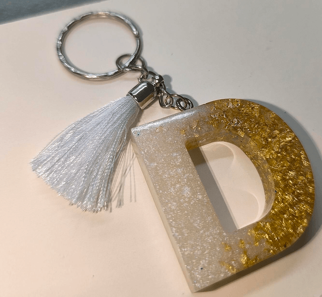 Porte clés initiale "D" blanc nacré et feuilles d'or 