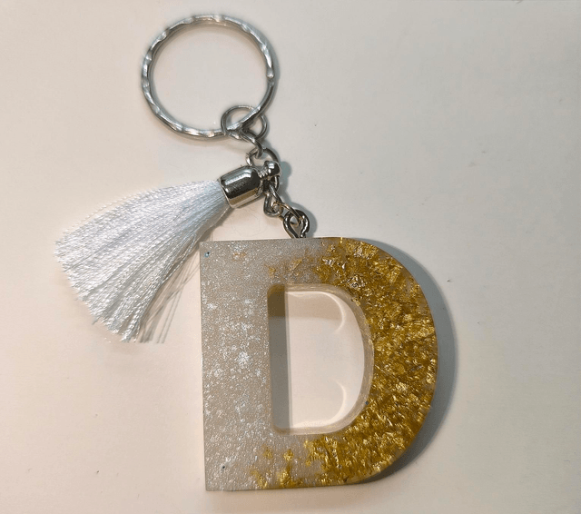 Porte clés initiale "D" blanc nacré et feuilles d'or 