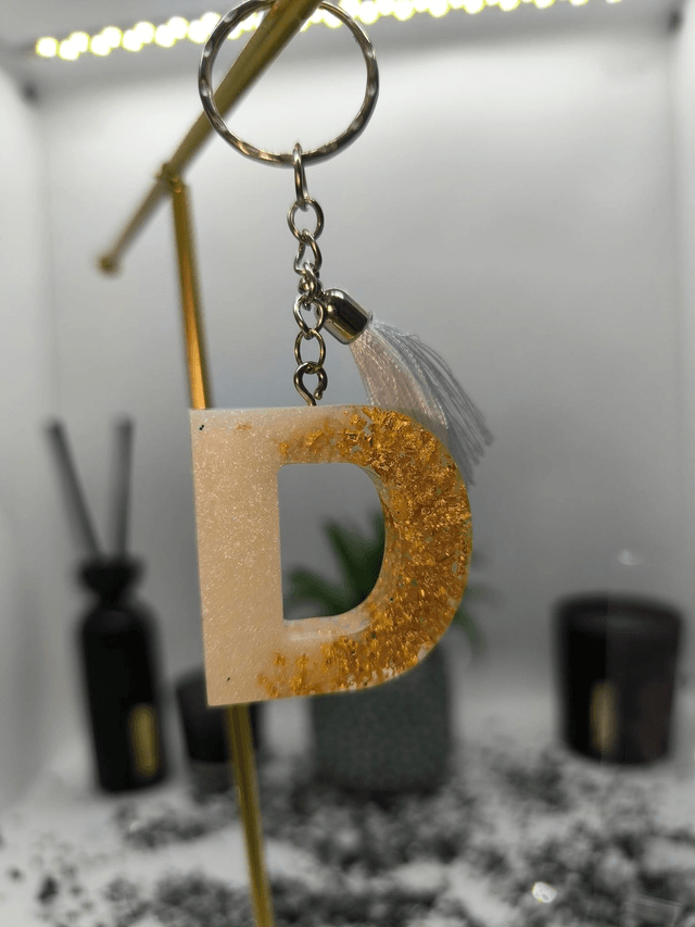 Porte clés initiale "D" blanc nacré et feuilles d'or 